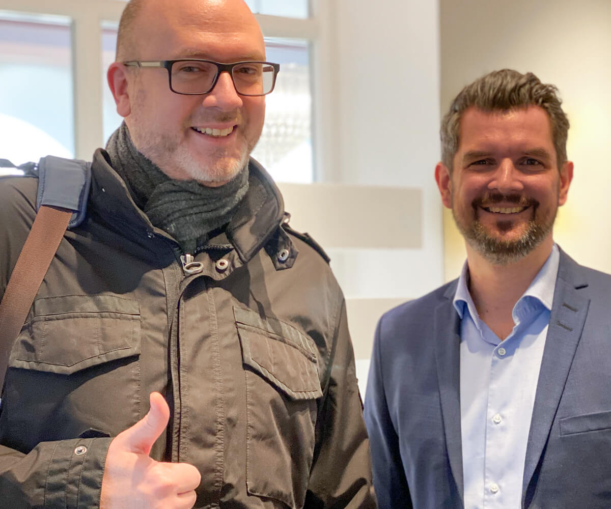 Smilende mand giver tommelfingrene op