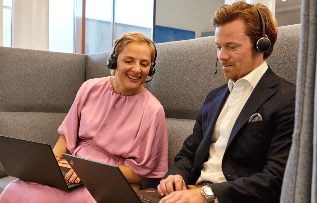 Billede af to kolleger, der sidder i en sofa og snakker